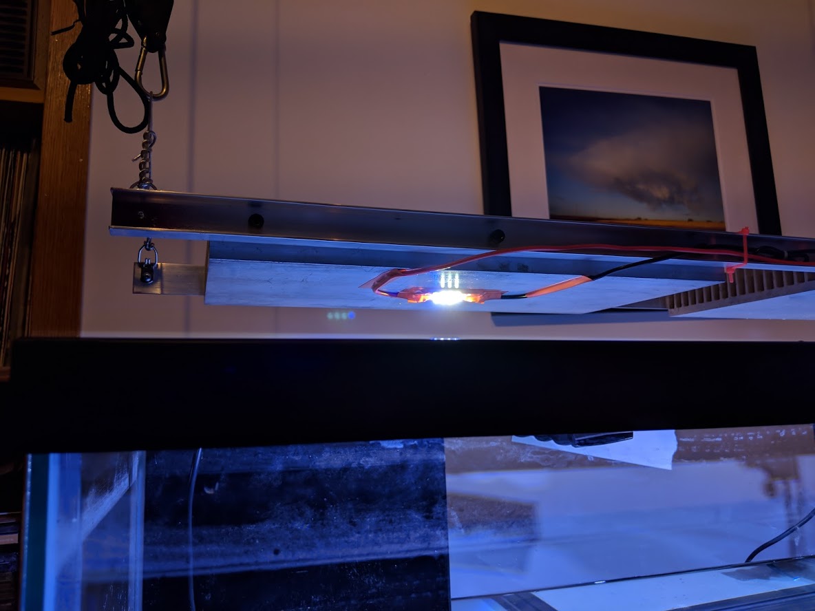 Photograph of aluminum light fixture over aquarium with whiteish blue light